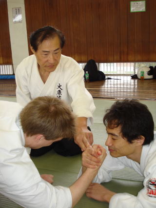 長尾全祐師範が門弟の腕相撲に手を添える稽古風景