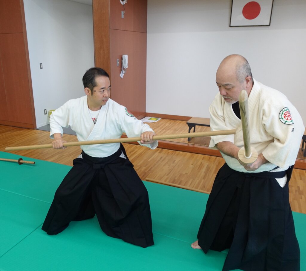 杖を使った合氣道の稽古で、技の中の崩れや力の流れを確認している場面
